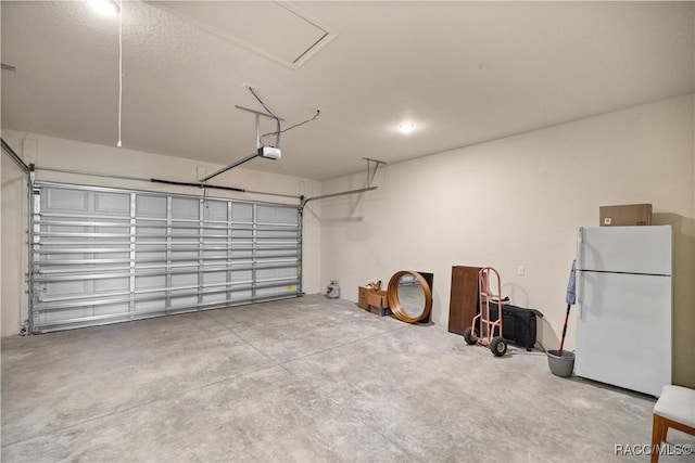 garage with white refrigerator and a garage door opener