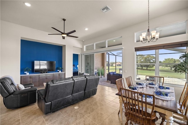 tiled living room with ceiling fan with notable chandelier