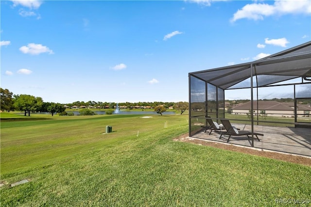 view of yard featuring glass enclosure, a patio area, and a water view