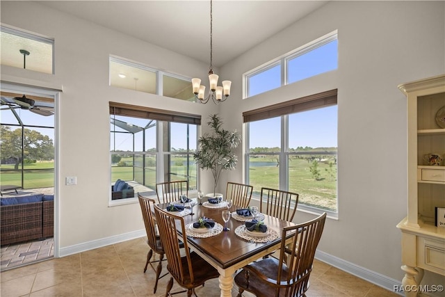 tiled dining room with ceiling fan with notable chandelier