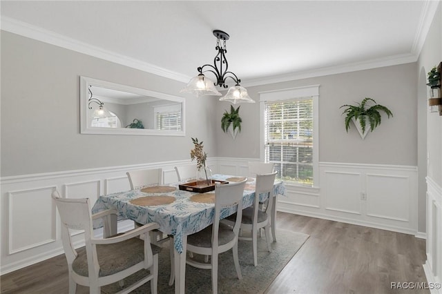 dining space with crown molding, hardwood / wood-style floors, and a chandelier