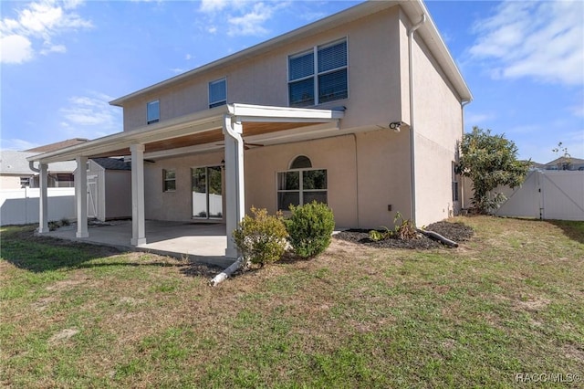 back of property with a yard and a patio