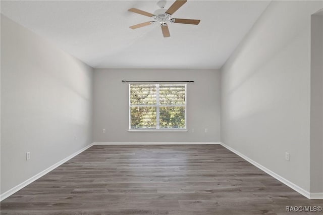 spare room with dark hardwood / wood-style flooring and ceiling fan