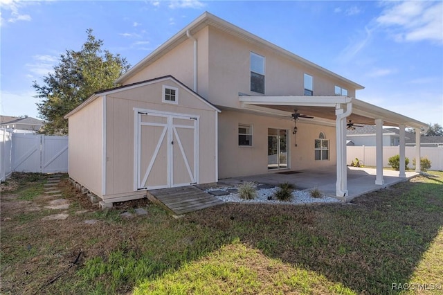 back of house featuring a patio, ceiling fan, and a lawn