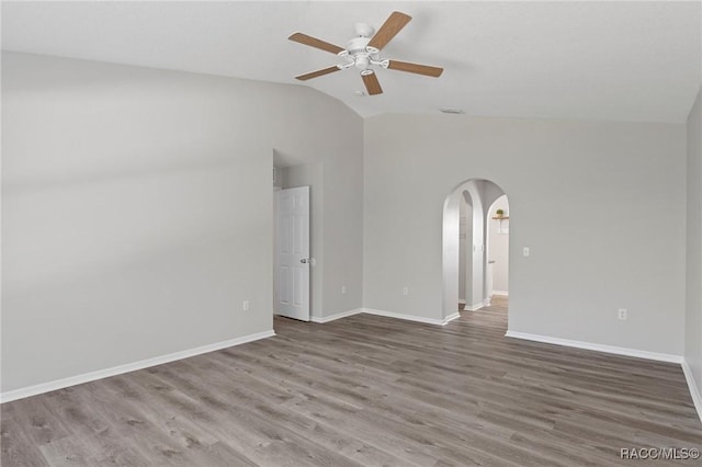 spare room featuring wood-type flooring, vaulted ceiling, and ceiling fan