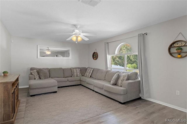 living room with ceiling fan and light hardwood / wood-style flooring