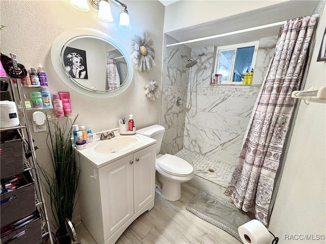 bathroom featuring vanity, wood-type flooring, toilet, and a shower with shower curtain