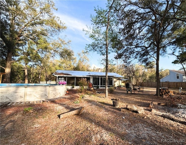 rear view of house with a fenced in pool