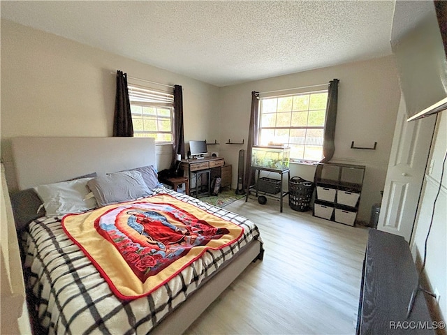 bedroom featuring a textured ceiling and light wood-type flooring