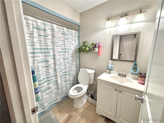 bathroom with vanity, toilet, a textured ceiling, and a shower with curtain