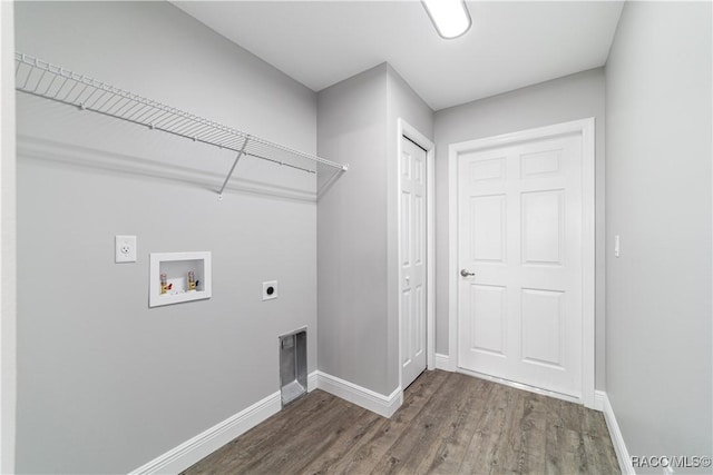 clothes washing area with electric dryer hookup, washer hookup, dark wood-type flooring, and baseboards