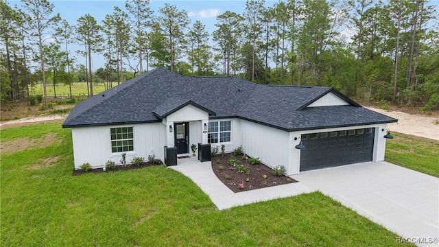 view of front of home featuring a garage, driveway, a front lawn, and roof with shingles