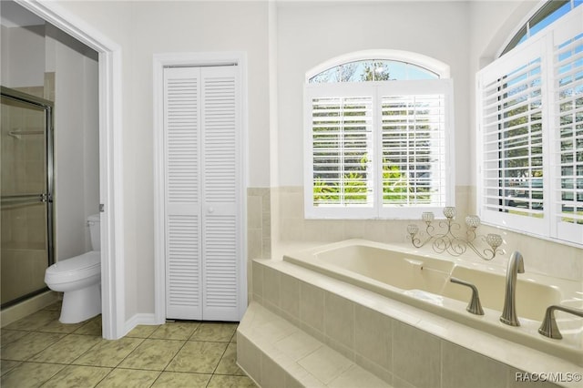 bathroom with a bath, a shower stall, a closet, tile patterned floors, and toilet