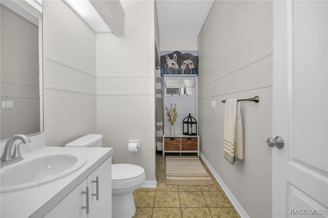 bathroom featuring vanity, tile patterned floors, toilet, and baseboards