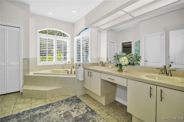 full bathroom with tile patterned floors, a garden tub, a closet, and a sink