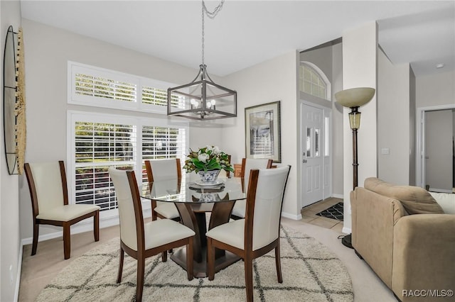 dining space featuring a chandelier and baseboards