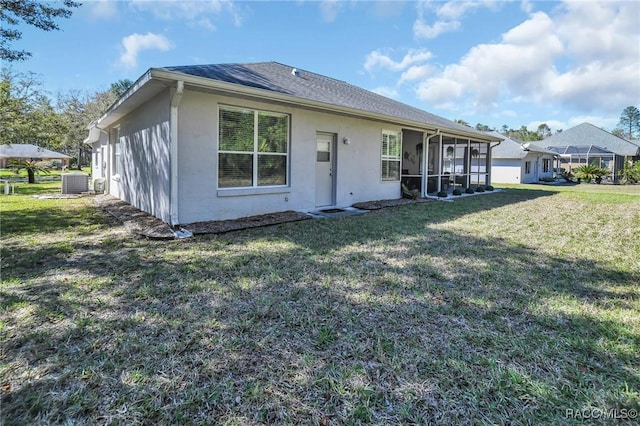 view of front of property featuring stucco siding, a front lawn, a sunroom, a shingled roof, and central AC unit