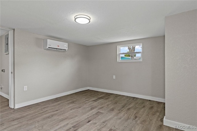 1 Taft St, Beverly Hills, FL 34465 - below grade area featuring a wall unit AC, wood finished floors, baseboards, electric panel, and a textured ceiling