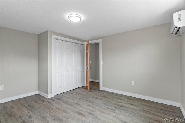 1 Taft St, Beverly Hills, FL 34465 - unfurnished bedroom featuring wood finished floors, baseboards, a wall unit AC, and a closet