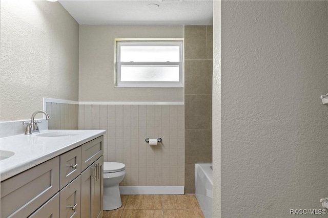 1 Taft St, Beverly Hills, FL 34465 - full bath with a textured wall, toilet, a bath, double vanity, and tile patterned flooring