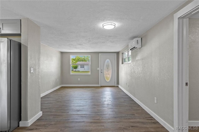 1 Taft St, Beverly Hills, FL 34465 - entryway featuring a textured wall, an AC wall unit, a textured ceiling, dark wood-style flooring, and baseboards