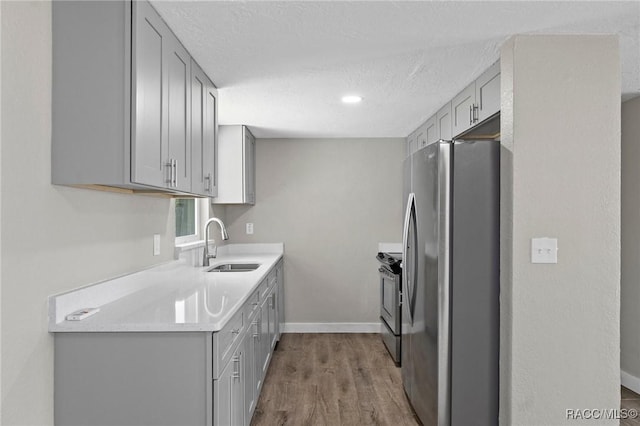 1 Taft St, Beverly Hills, FL 34465 - kitchen featuring appliances with stainless steel finishes, gray cabinetry, a sink, light countertops, and a textured ceiling