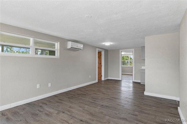 1 Taft St, Beverly Hills, FL 34465 - empty room featuring a wall mounted air conditioner, a textured ceiling, baseboards, and dark wood-style flooring