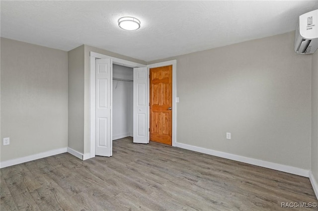 1 Taft St, Beverly Hills, FL 34465 - unfurnished bedroom with a wall mounted air conditioner, wood finished floors, and baseboards