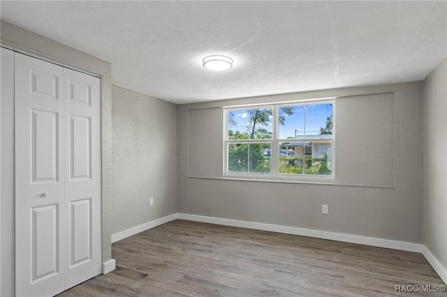 1 Taft St, Beverly Hills, FL 34465 - unfurnished bedroom with wood finished floors, baseboards, a closet, and a textured ceiling