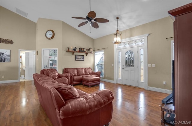 living room with hardwood / wood-style floors, high vaulted ceiling, and ceiling fan