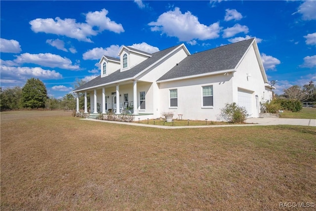 view of front of house with a garage, covered porch, and a front yard