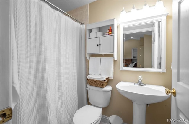 bathroom featuring toilet and a shower with shower curtain