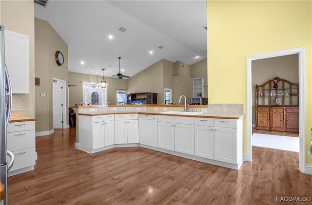 kitchen featuring white cabinetry, decorative light fixtures, kitchen peninsula, and sink