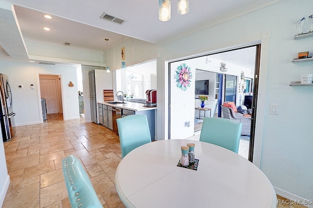 dining space featuring crown molding and sink