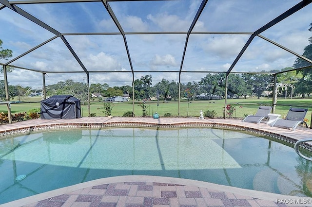 view of swimming pool with a lanai, a lawn, and a patio