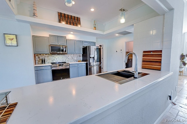 kitchen with sink, stainless steel appliances, crown molding, gray cabinets, and decorative backsplash