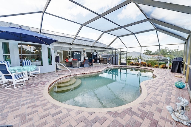 view of swimming pool with glass enclosure and a patio