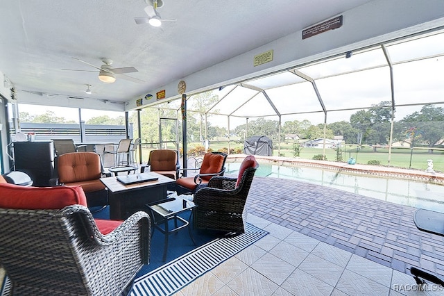 view of patio / terrace featuring ceiling fan, glass enclosure, and an outdoor living space with a fire pit