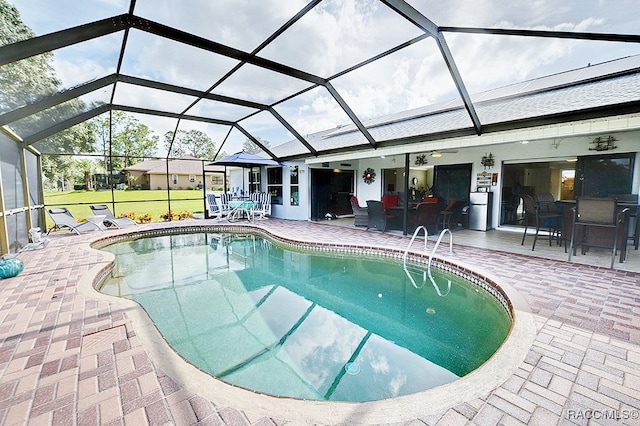 view of swimming pool with a patio, glass enclosure, and ceiling fan