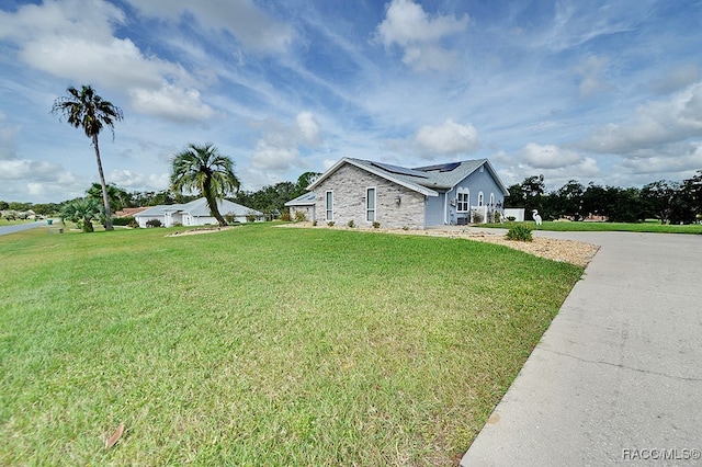 view of property exterior with solar panels and a yard