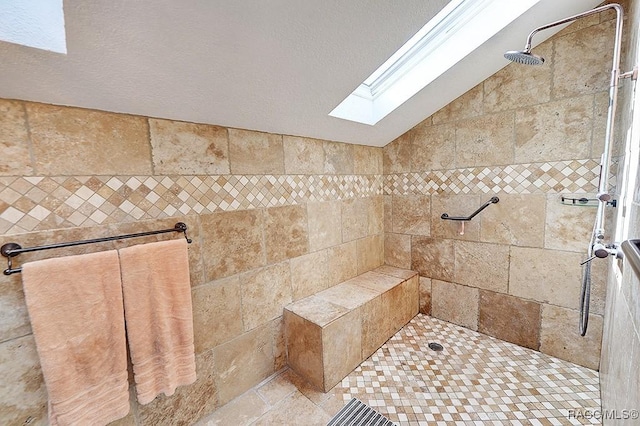 bathroom featuring a tile shower and lofted ceiling with skylight