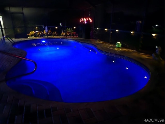 view of pool at twilight