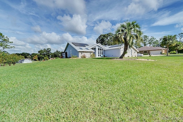 view of front of property featuring solar panels and a front lawn