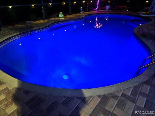 view of pool at twilight