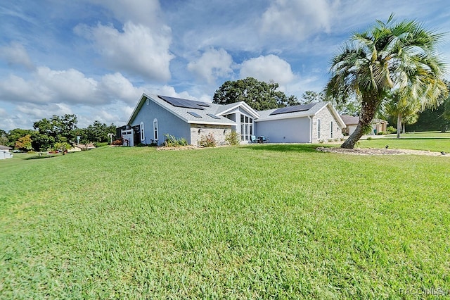 single story home with solar panels and a front yard