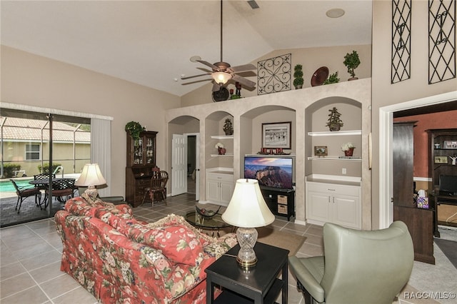 tiled living room with ceiling fan, built in features, and high vaulted ceiling