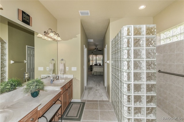 bathroom featuring ceiling fan, tile patterned flooring, vanity, and tiled shower