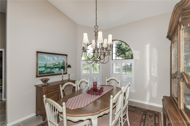 tiled dining area featuring lofted ceiling and an inviting chandelier