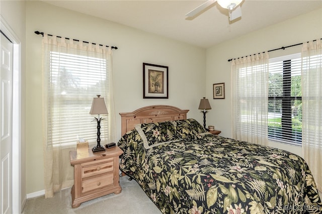 carpeted bedroom featuring ceiling fan and multiple windows