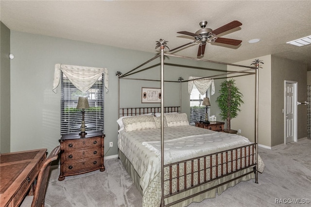 carpeted bedroom featuring ceiling fan and a textured ceiling